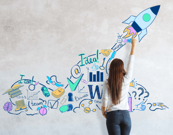 Una donna disegna su una parete grigia un razzo azzurro che parte, rappresenta la crescita di una startup.