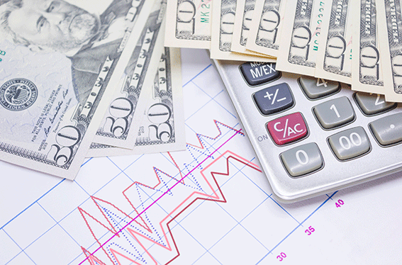 Banconote, calcolatrice e grafico sul tavolo. Rappresentano la finanza nel 2023.